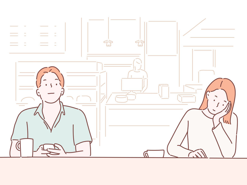 Ginger man and woman sitting close to each other in a cafe, the man holding his phone and woman leaning on her palm.